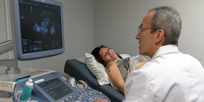 Dr Luis Tobon using ultrasound of woman.